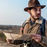 Closeup of a Male hiker using a map to locate the destination