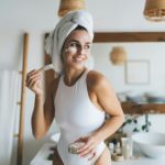 Smiling female doing skin care routine