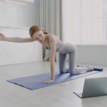 Young woman practicing yoga by video tutorial. Posture exercise. Home classes on quarantine.
