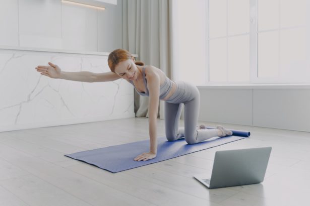 Young woman practicing yoga by video tutorial. Posture exercise. Home classes on quarantine.